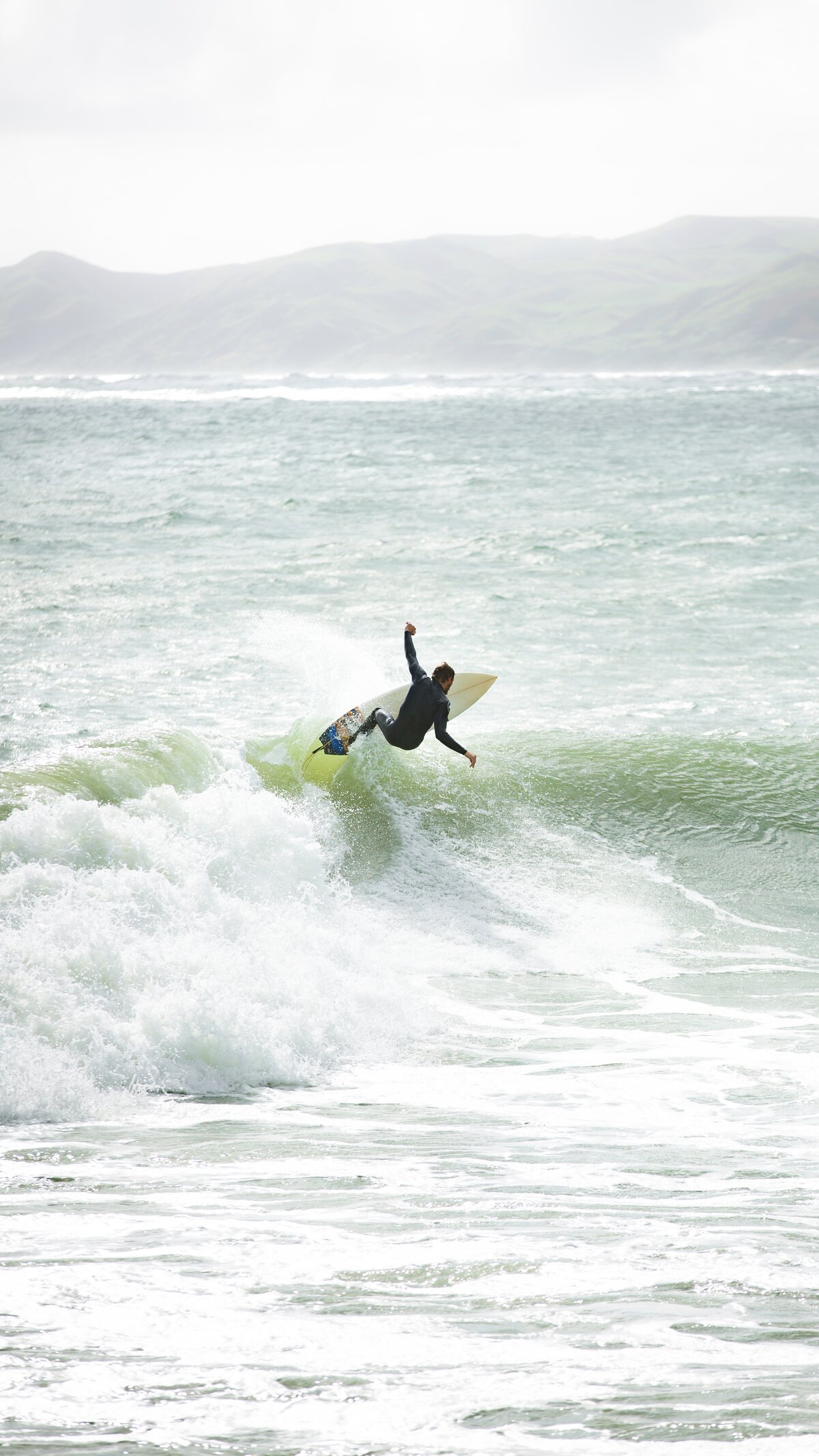 Surfer launching off the lip of a wave